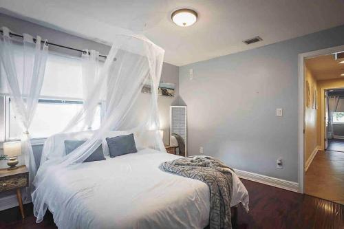 a bedroom with a white bed with a canopy at Heated Pool in Private House w/ Fire Pit in Seffner