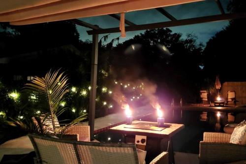 a table with two candles on a patio at night at Heated Pool in Private House w/ Fire Pit in Seffner