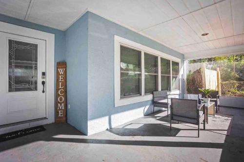 a porch with chairs and a blue wall and a door at Heated Pool in Private House w/ Fire Pit in Seffner