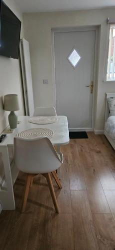 Habitación con 2 sillas, mesa y puerta en Self-contained annex with private entrance, double bed, kitchen, bathroom, free car park - Near Cambridge, Duxford Air Museum and Addenbrooke's Hospital, en Cambridge