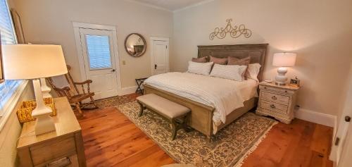 een slaapkamer met een bed, een stoel en een spiegel bij Walnut Hill Estate in West Jefferson