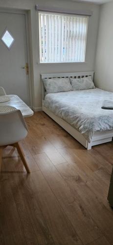a bedroom with a bed and a desk and a window at Self-contained annex with private entrance, double bed, kitchen, bathroom, free car park - Near Cambridge, Duxford Air Museum and Addenbrooke's Hospital in Cambridge
