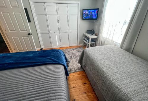 a bedroom with two beds and a door with a tv at Bluff Mountain Retreat in West Jefferson
