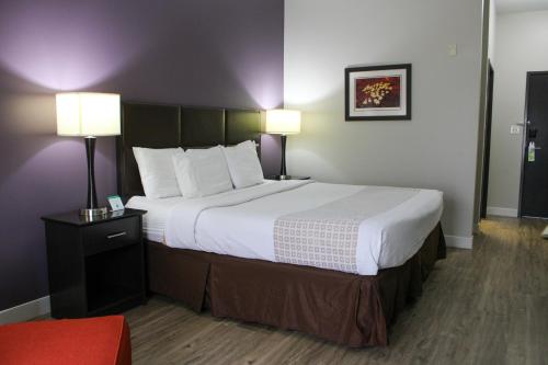 a large bed in a hotel room with two lamps at Parkwood Inn & Suites in Manhattan