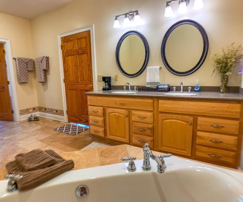 baño con lavabo y 2 espejos en Carolina Pines, en Grassy Creek