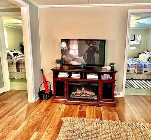 Il comprend un salon avec une cheminée et une télévision. dans l'établissement Cozy Cottage - New Rental 2023, à Lansing
