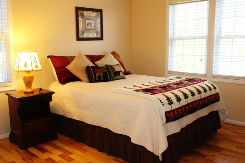 een slaapkamer met een bed met kussens en een lamp bij Sunset Over The Blue Ridge in Jefferson
