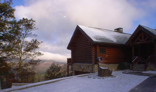 a log cabin in the mountains with snow on the ground at Picture Perfect in West Jefferson