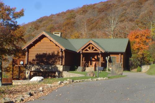 a log cabin with a mountain in the background at Picture Perfect in West Jefferson