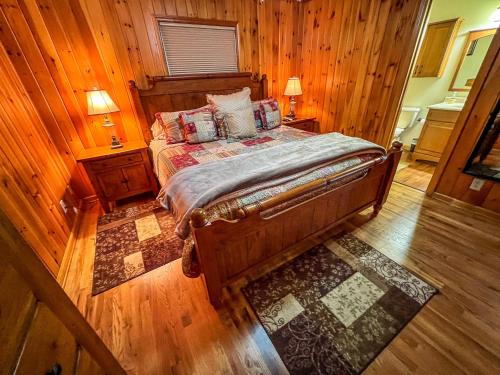 a bedroom with a bed with wooden walls and wood floors at Riverview Ridge in Piney Creek