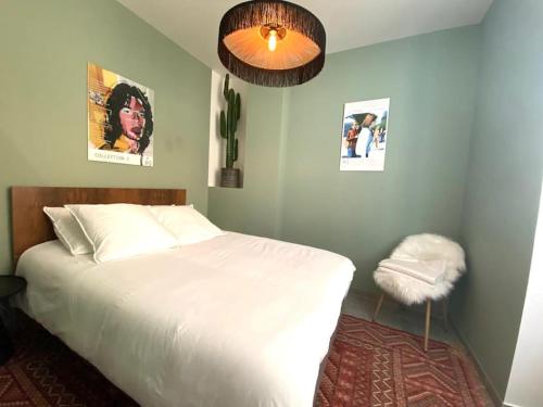 une chambre avec un lit blanc et une lampe dans l'établissement T2 Cocooning au coeur de Vienne, à Vienne