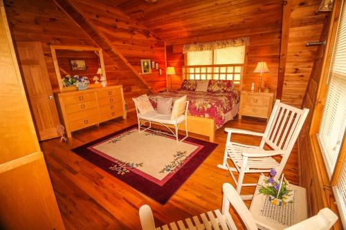 a bedroom with a bed and chairs in a cabin at Rest Assured in West Jefferson