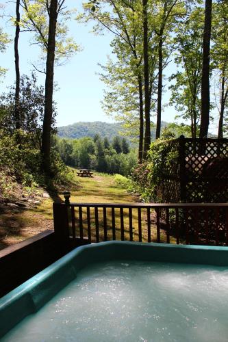a hot tub in a yard with a fence at Unforgettable in Grassy Creek