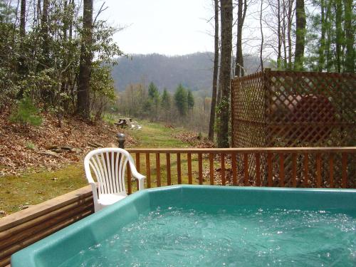 a plastic chair sitting next to a hot tub at Unforgettable in Grassy Creek