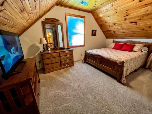 een slaapkamer met een bed en een tv in een kamer bij Above It All in Grassy Creek