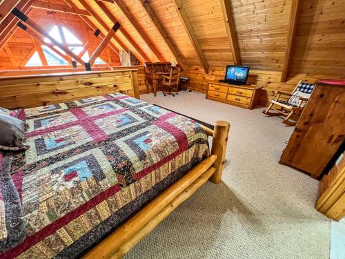 um quarto com uma cama e uma televisão num camarote em Dream Mountain Lodge em Grassy Creek