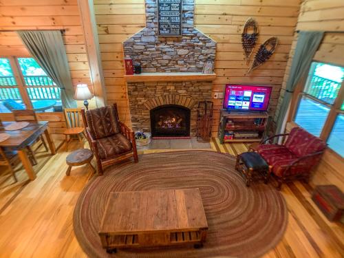 a living room with a fireplace in a log cabin at Pine Log Lodge in Jefferson