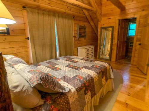 a bedroom with a bed in a log cabin at Pine Log Lodge in Jefferson