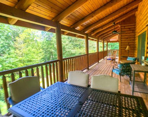 a screened in porch with a blue table and chairs at Pine Log Lodge in Jefferson