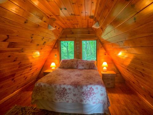 sypialnia z łóżkiem w drewnianym domku w obiekcie Haven Ridge w mieście Lansing