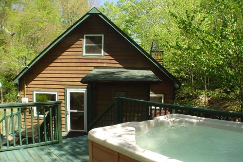 a house with a hot tub on a deck at Roaring Creek in Todd