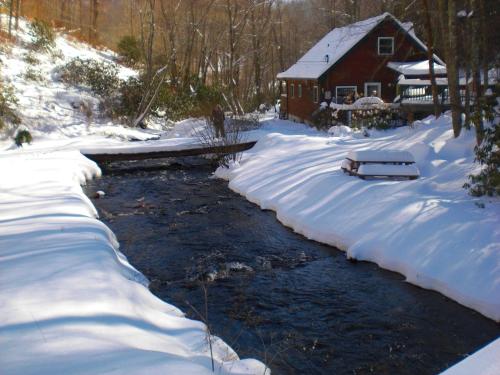 a river in front of a house in the snow at Roaring Creek in Todd