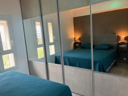 - une chambre avec un miroir et un lit dans l'établissement Village naturiste - Port-Nature 4 coursives vue mer - Le Point G., au Cap d'Agde