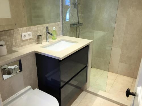 une salle de bain avec un lavabo et une douche dans l'établissement Maison Bleu, à Grimaud