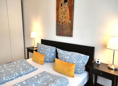 Schlafzimmer mit einem Bett mit blauen und gelben Kissen in der Unterkunft Apartment L - comfort in Leipzig