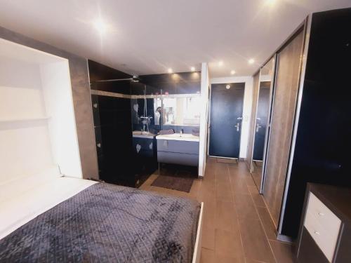 um quarto com uma cama e uma casa de banho com um lavatório em "L'eden" village naturiste cap d'agde em Cap d'Agde
