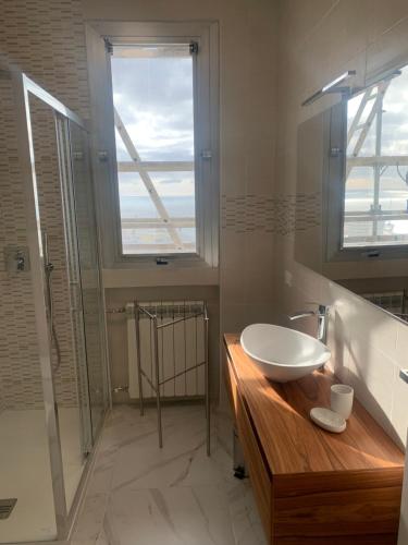 a bathroom with a sink and a glass shower at ATTICO GENOVA con POSTO AUTO in Genova
