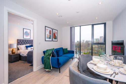 ein Wohnzimmer mit einem blauen Sofa und einem Tisch in der Unterkunft City Cosy 1 bed - Perfect for Long Stays By Valore Property Services in Manchester