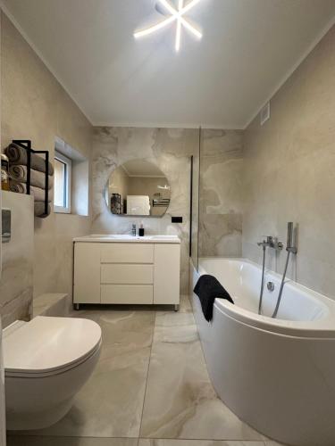 un bagno con vasca, WC e lavandino di Zielona Góra Apartament a Jugów