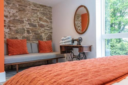 a bedroom with a bed and a mirror and a bench at Garden Rooms @ Drumagosker Rural Retreats in Ardmore