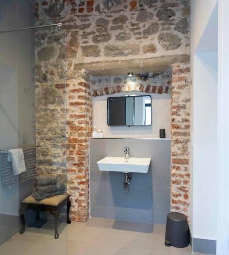a bathroom with a sink and a tv on the wall at Garden Rooms @ Drumagosker Rural Retreats in Ardmore