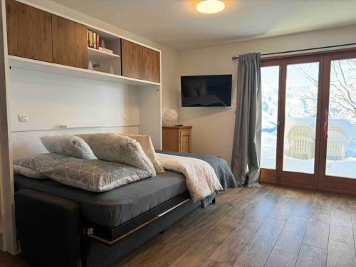 蒙塔纳New: appartement refait à neuf avec vue!的一间卧室设有一张床和一个滑动玻璃门