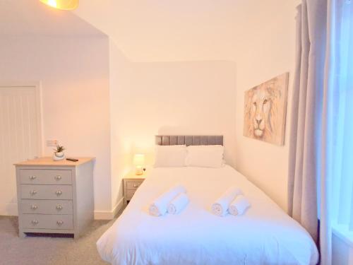 a bedroom with a bed with two slippers on it at Burnley Terraced House by BEVOLVE - Free Parking 2 in Burnley