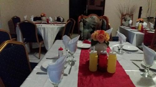 einem langen Tisch mit einem roten und weißen Tischtuch in der Unterkunft Palm Tree Guest House in Manzini