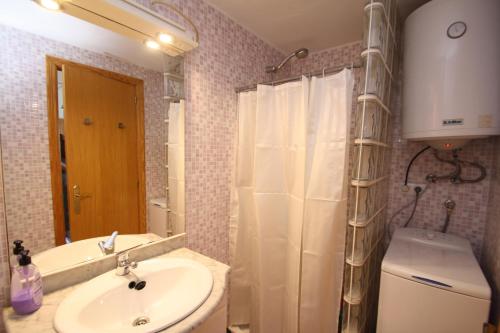 uma casa de banho com um lavatório, um WC e um espelho. em Precioso estudio primera linea Fossa-Puerto Calpe em Calpe