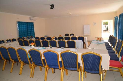 einen Konferenzraum mit einem langen Tisch und Stühlen in der Unterkunft Palm Tree Guest House in Manzini