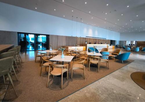 a restaurant with tables and chairs in a room at Montebelo Aguieira Lake Resort & Spa in Mortágua