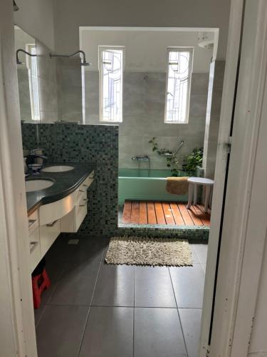 een badkamer met een bad, een wastafel en een douche bij en el corazón del Barrio Sur in Montevideo