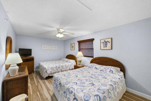 sypialnia z 2 łóżkami i wentylatorem sufitowym w obiekcie 201 Sandy Shores Condos w St Pete Beach