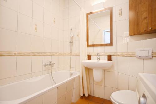a bathroom with a sink and a tub and a toilet at Victus Apartamenty, Apartament Daria Luiza in Sopot