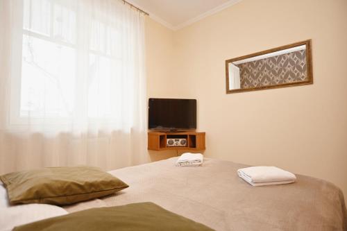 a bedroom with a bed with a tv and a window at Victus Apartamenty, Apartament Daria Luiza in Sopot