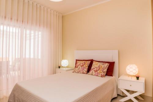 - une chambre avec un lit blanc et une fenêtre dans l'établissement NEW !! Two Bedroom Cabanas Tavira - Banda Musical ORANGE, à Tavira