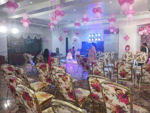 a group of chairs in a room with pink balloons at MR JaiSwaL DharMShalA in Sultānpur