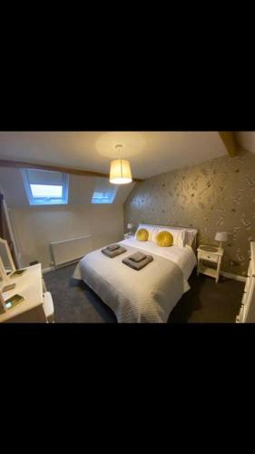 a bedroom with a bed with two towels on it at Barn Cottage in Youlgreave