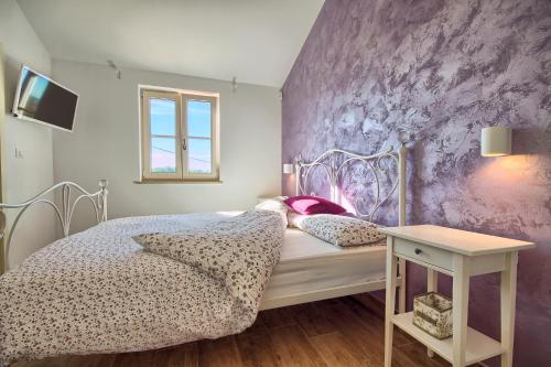a bedroom with a bed and a purple wall at Villa Fumeti in Barban