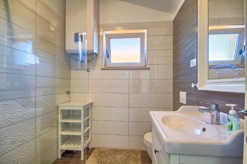a bathroom with a sink and a toilet and a window at Villa Fumeti in Barban